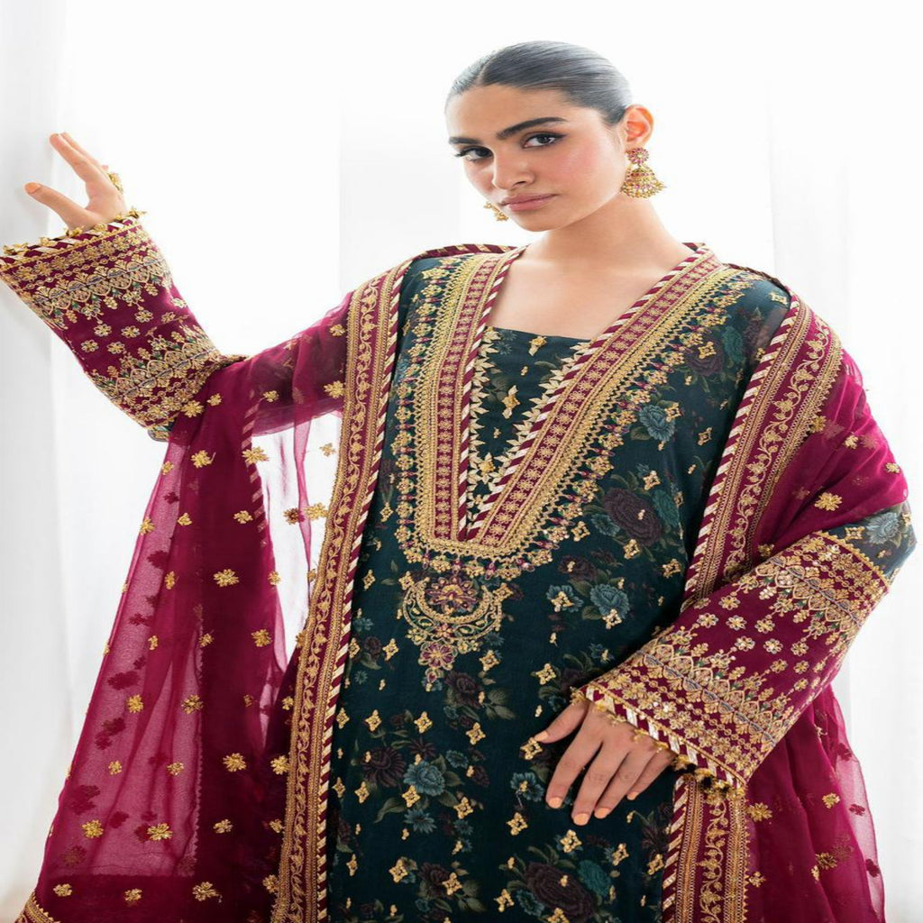 Woman wearing a traditional embroidered outfit with a maroon dupatta against a white background