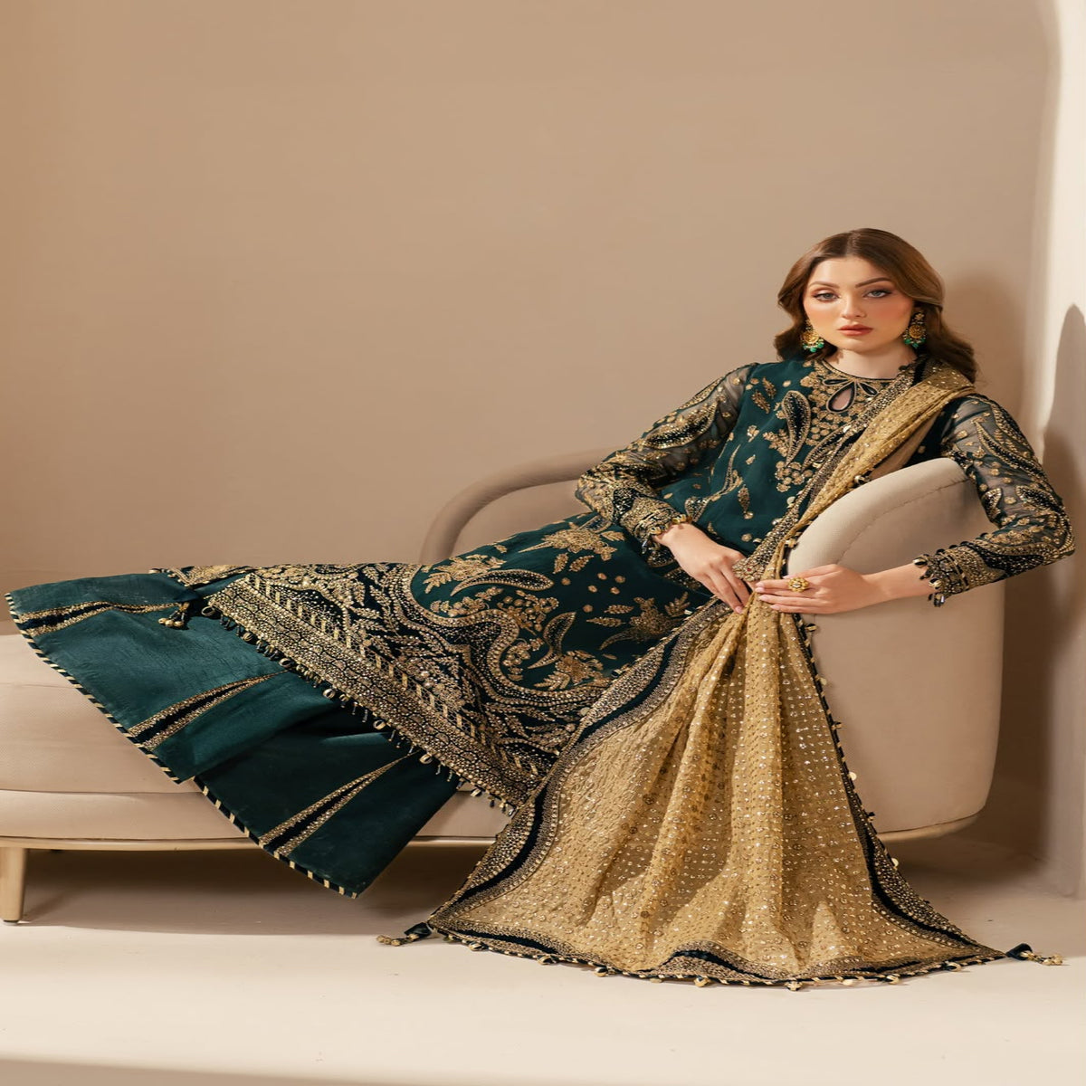 Woman in a traditional embroidered outfit sitting on a chair with a beige background