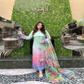 Woman in a colorful dress standing in front of a green 'KORU' sign.