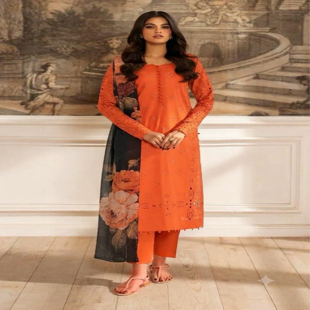 A woman models a vibrant orange kurta set with floral print panels, standing in front of a classical wall mural and light wood flooring.