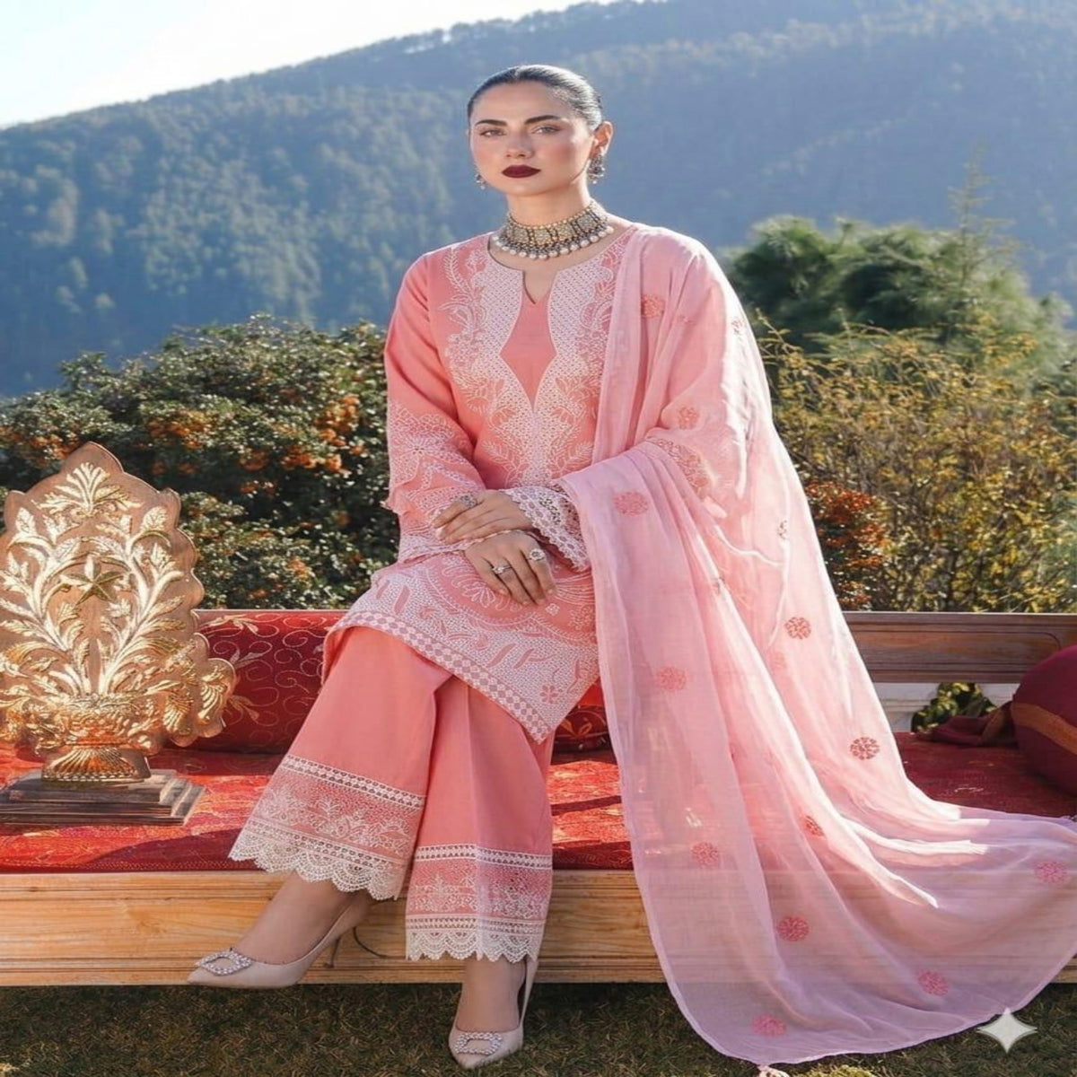 Woman in a pink traditional outfit with a scenic background
