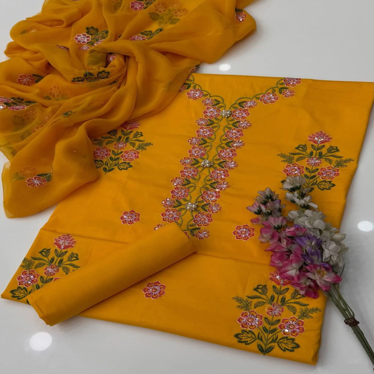 Yellow fabric with floral embroidery on a white background