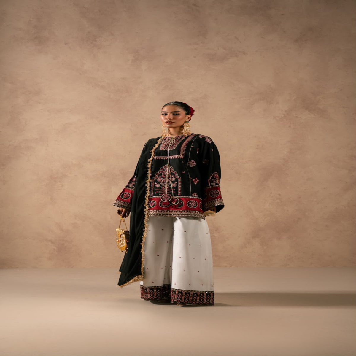 Woman wearing a traditional outfit with intricate patterns against a beige background