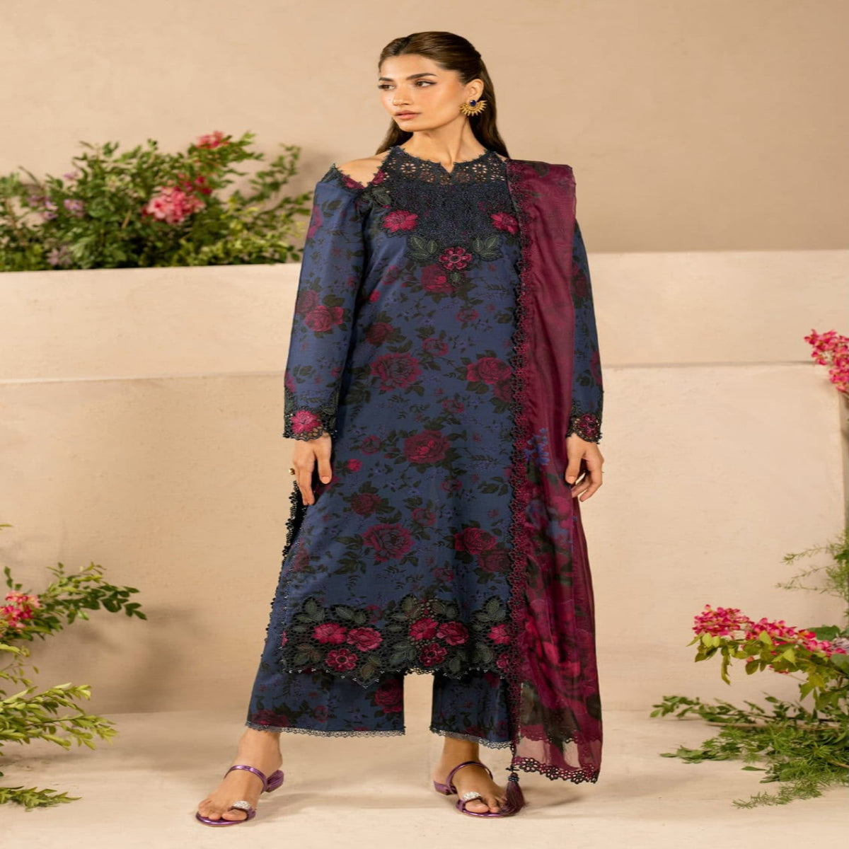 Woman wearing a dark blue floral dress with a matching dupatta against a neutral background