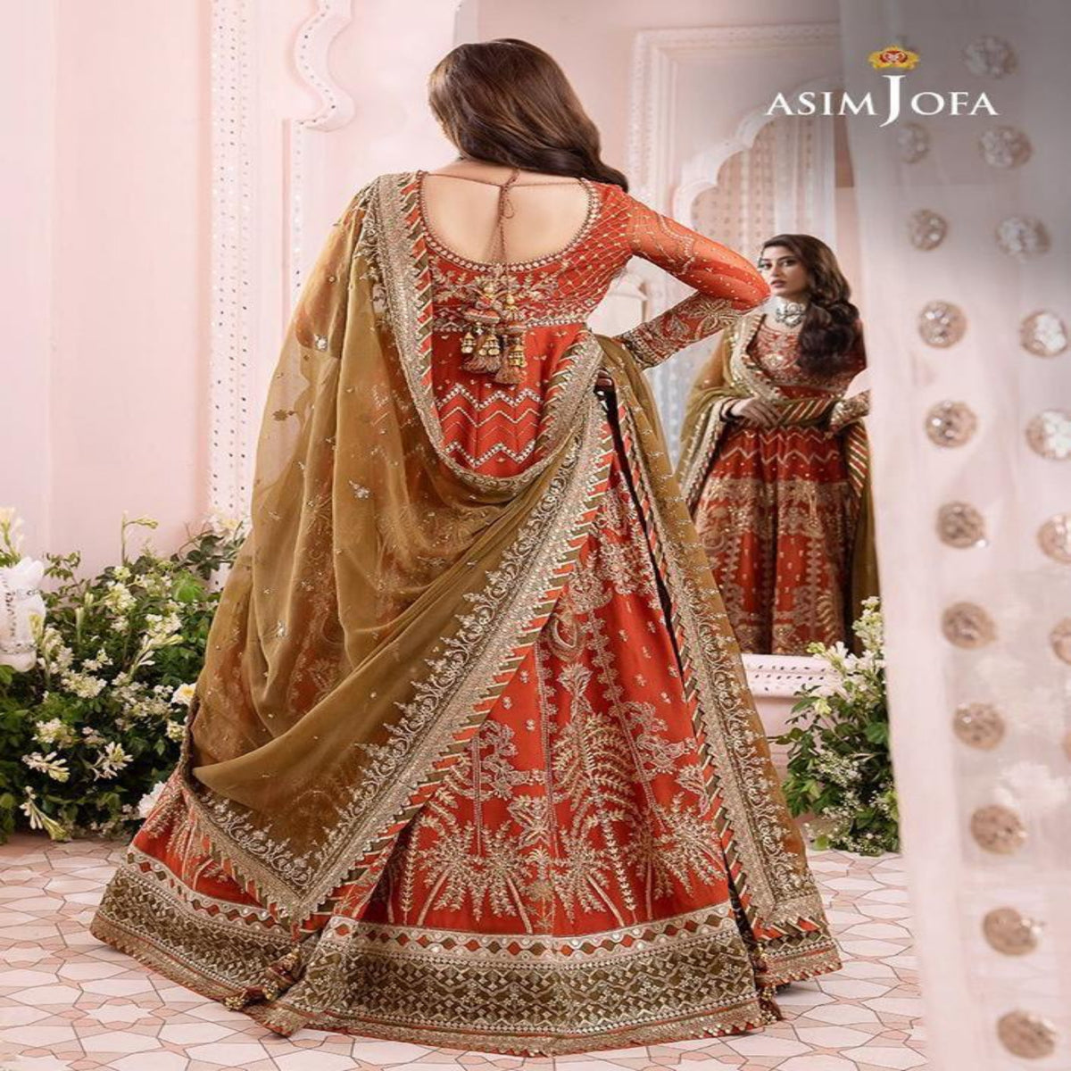 Woman in a traditional red and gold embroidered outfit standing in front of a mirror.